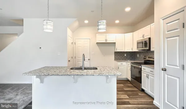 a kitchen with stainless steel appliances granite countertop a sink a stove and a refrigerator