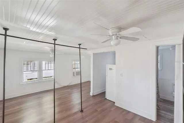 a view of a room with wooden floor and a ceiling fan