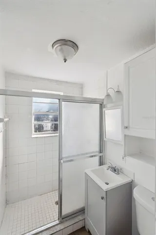 a bathroom with a sink a toilet and shower