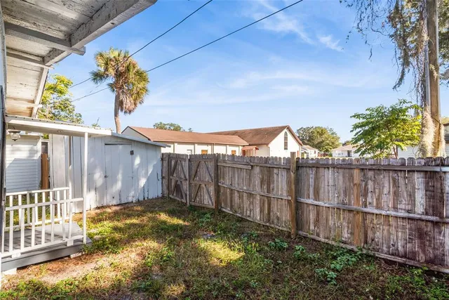 a view of a backyard with wooden fence