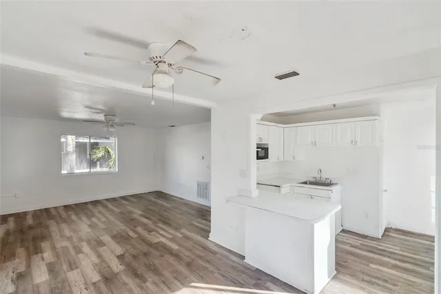 a view of a kitchen with a sink dishwasher and a stove with wooden floor