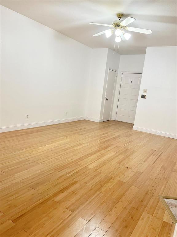 8545 Midpark Road, Unit 11 Dallas, TX 75240 - Photo 3 of 19 an empty room with wooden floor and ceiling fan