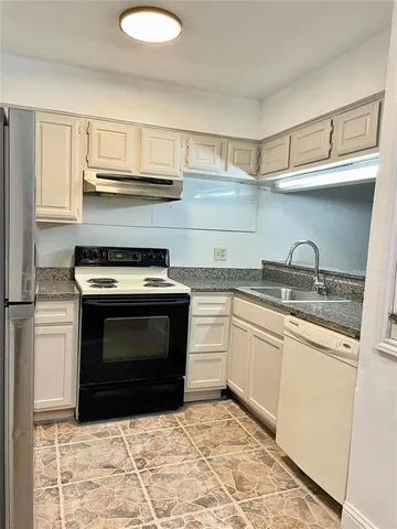 a kitchen with granite countertop a stove and a sink