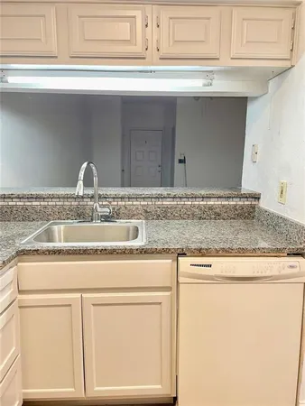 a kitchen with stainless steel appliances granite countertop a refrigerator a sink a stove and white cabinets