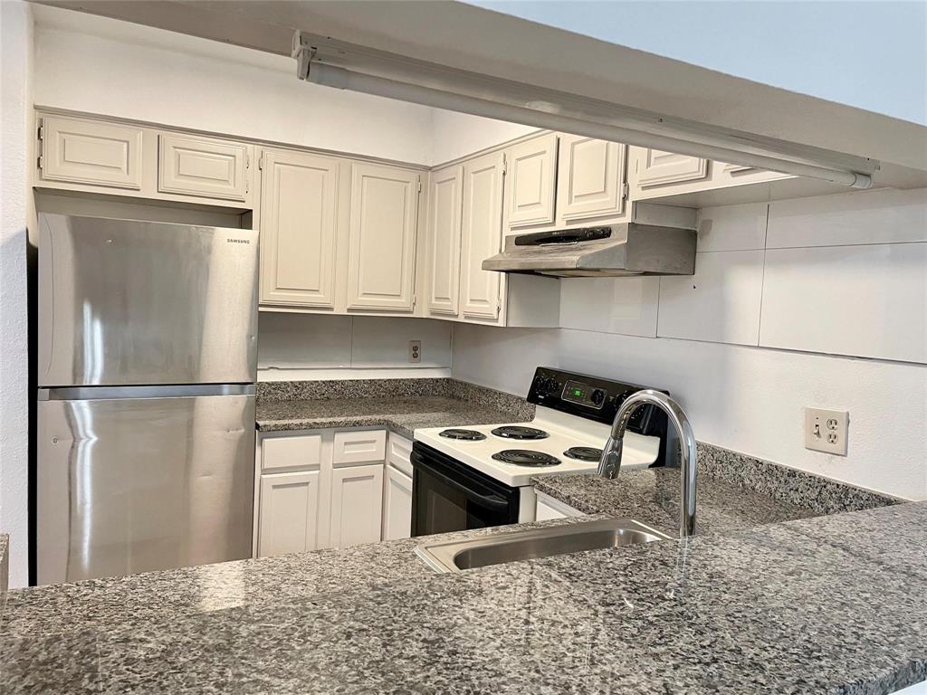 8545 Midpark Road, Unit 11 Dallas, TX 75240 - Photo 6 of 19 a kitchen with stainless steel appliances granite countertop a refrigerator a sink a stove and white cabinets