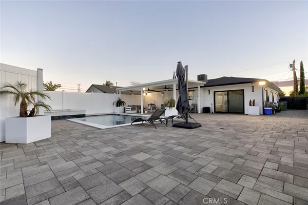 a view of a house with backyard and sitting area