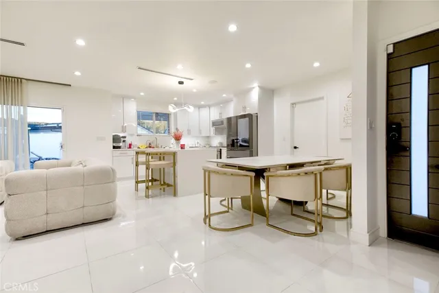 a living room with furniture and a dining table with kitchen view