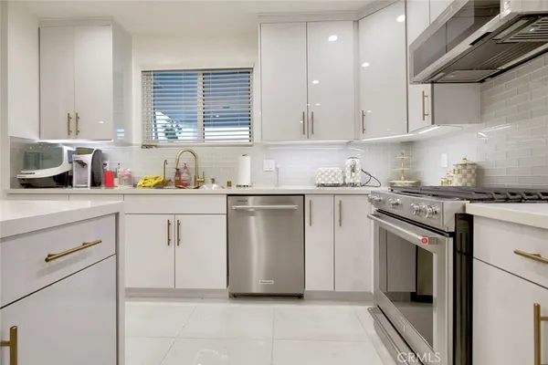a kitchen with white cabinets stainless steel appliances and sink