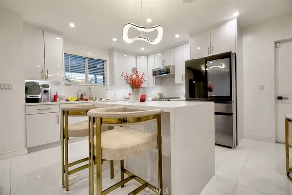 a kitchen with a sink a refrigerator and cabinets