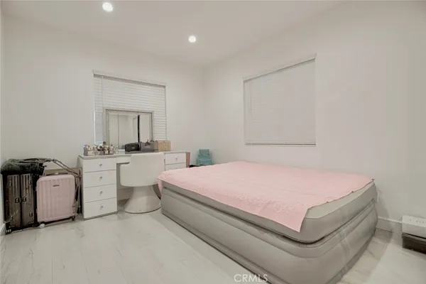 a bedroom with a white bed and white walls