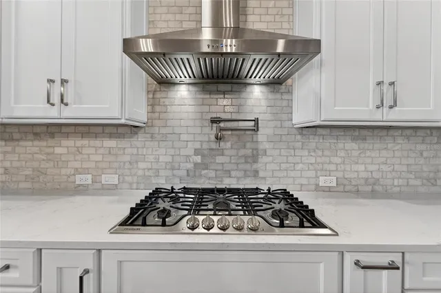 a dining room with wooden floor a chandelier a wooden table and chairs