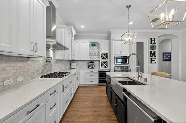 a dining room with furniture large windows and a chandelier