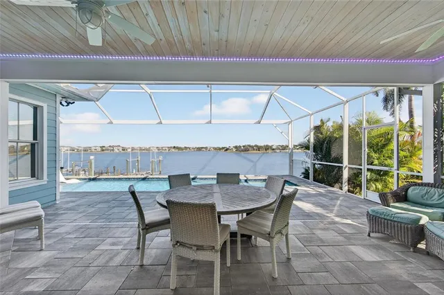 a kitchen with stainless steel appliances kitchen island granite countertop a refrigerator a oven and white cabinets with wooden floors