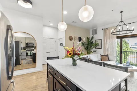 a kitchen with stainless steel appliances granite countertop a sink a stove cabinets and living room view