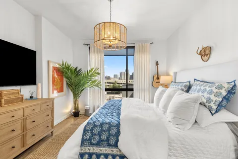 a living room with furniture a flat screen tv and a potted plant