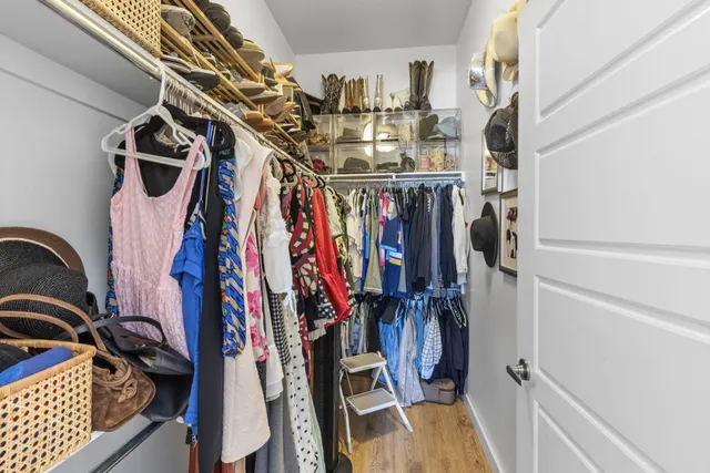 a view of walk in closet with clothes and shoes