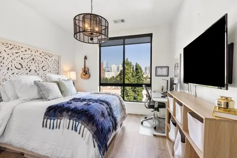 a bedroom with a bed window and a flat screen tv