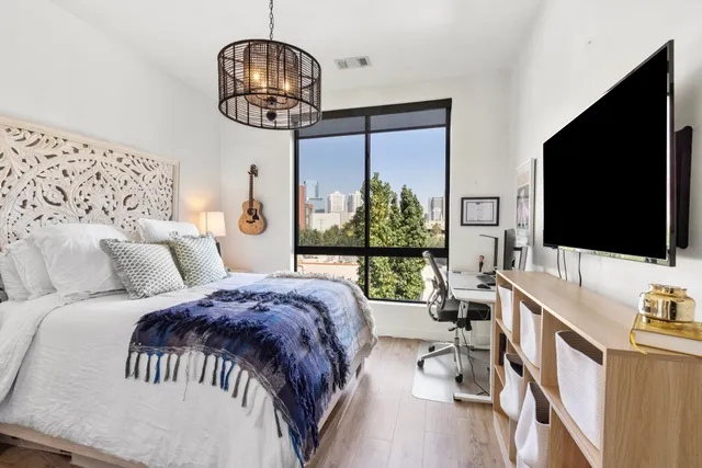 a bedroom with a bed window and a flat screen tv