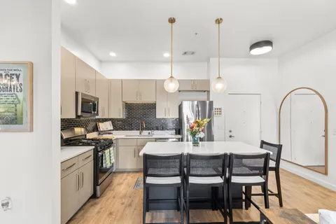 a kitchen with a dining table chairs and white cabinets