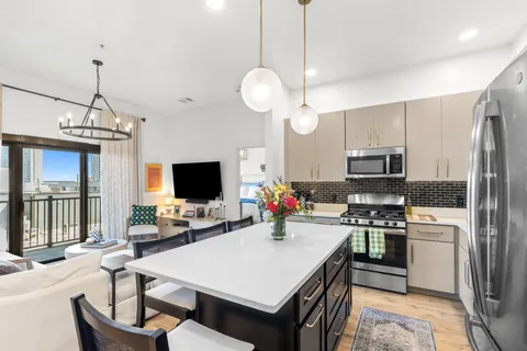a kitchen with a chandelier a dining table and chairs