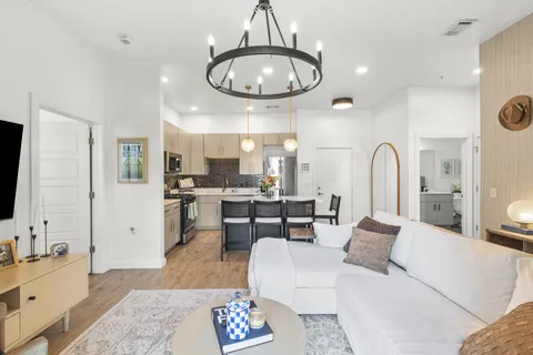 a living room with furniture a flat screen tv and a large window