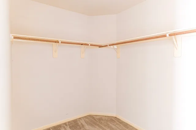 an empty room with a window and a ceiling fan