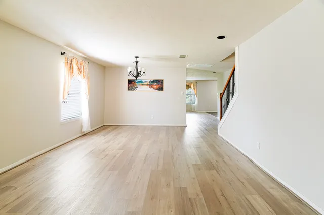 a view of a livingroom with wooden floor and stairs