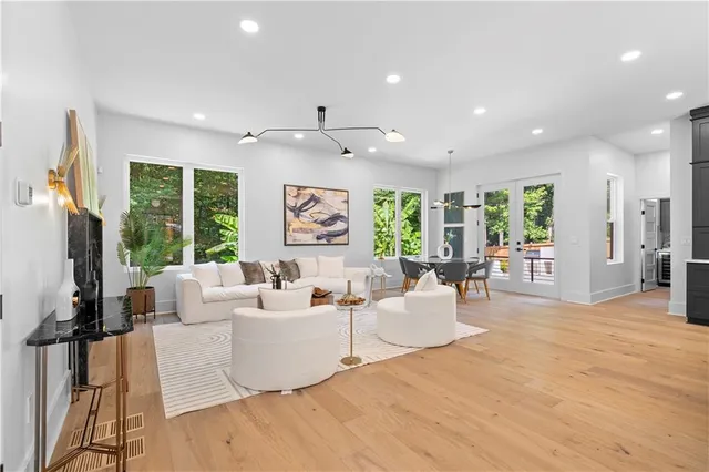 a spacious bedroom with a bed a chandelier and a large window