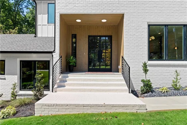 a view of a kitchen with kitchen island a large counter space a sink a window and stainless steel appliances
