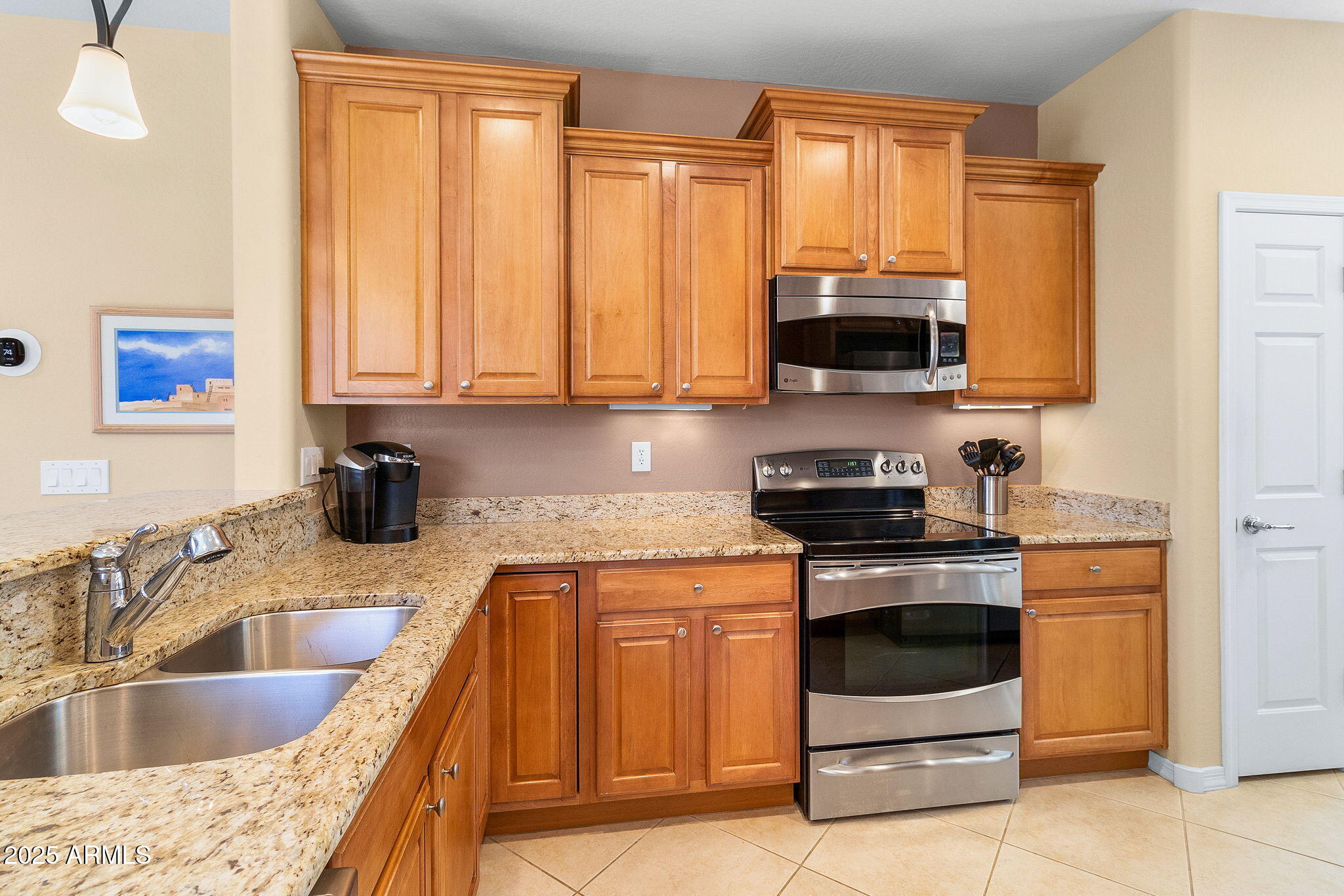 21280 North 262nd Drive Buckeye, AZ 85396 - Photo 3 of 51 a kitchen with granite countertop a sink a stove and a microwave