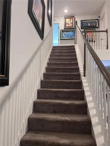 a view of a hallway with wooden floor and windows