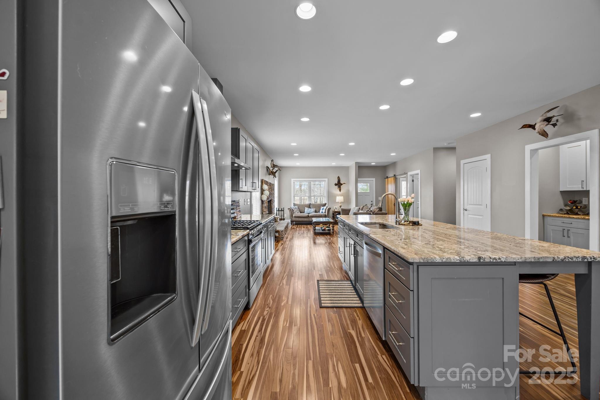 5321 Vesuvius Furnace Road Iron Station, NC 28080 - Photo 17 of 48 a view of a kitchen island a large counter top space a sink and stainless steel appliances