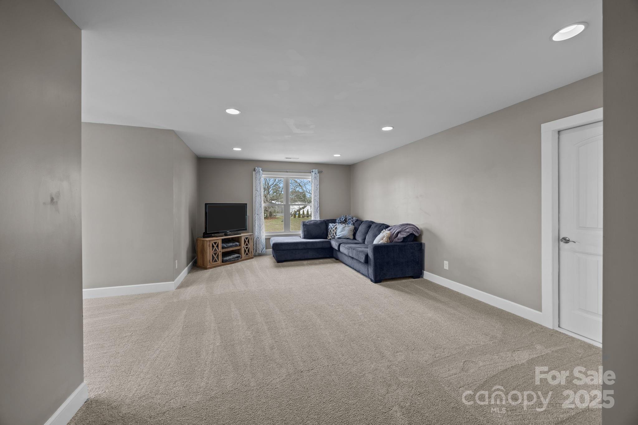 5321 Vesuvius Furnace Road Iron Station, NC 28080 - Photo 32 of 48 a living room with furniture a flat screen tv and a large window