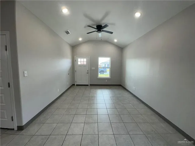an empty room with windows and ceiling fan