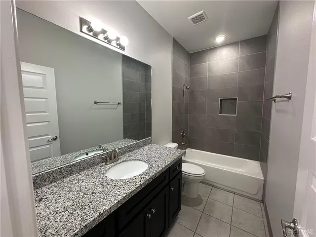 a bathroom with a granite countertop sink a toilet and shower