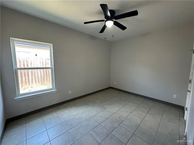an empty room with a ceiling fan and window