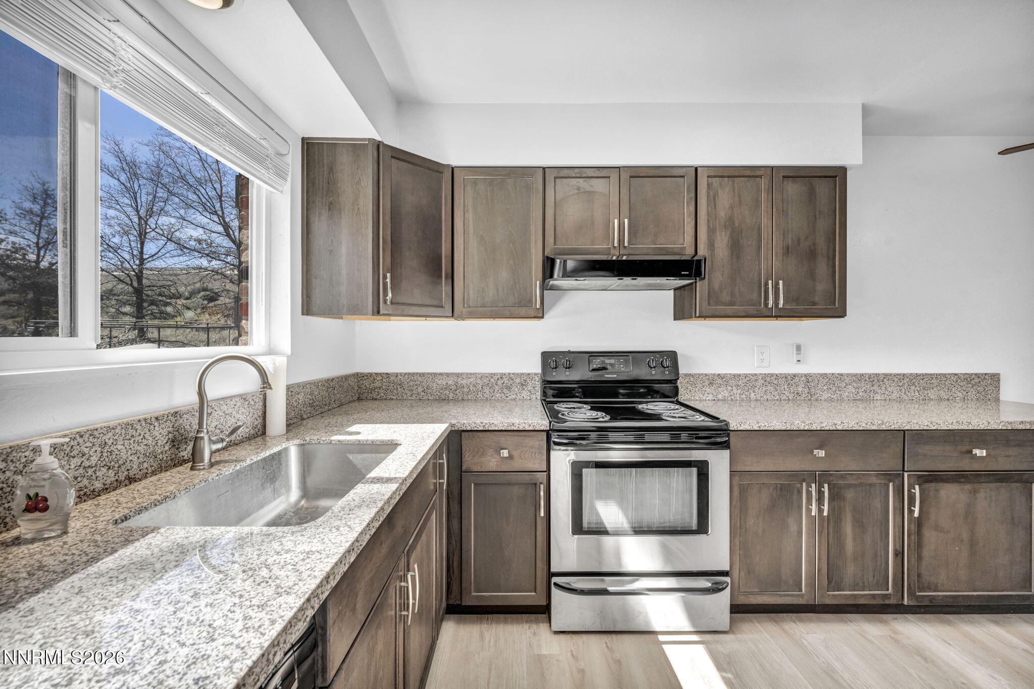 312 Smithridge Park Reno, NV 89502 - Photo 5 of 21 a kitchen with granite countertop a stove sink and cabinets