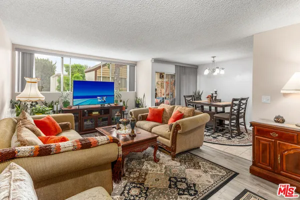 a living room with furniture kitchen view and a window