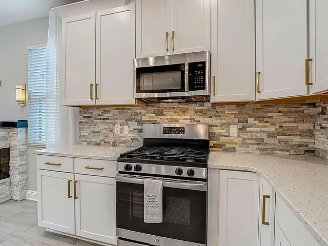 a kitchen with a sink a stove and cabinets