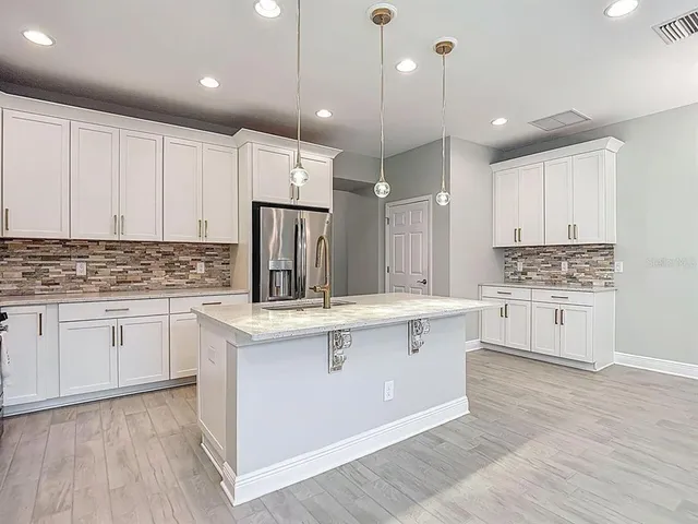a kitchen with kitchen island a sink stainless steel appliances and cabinets