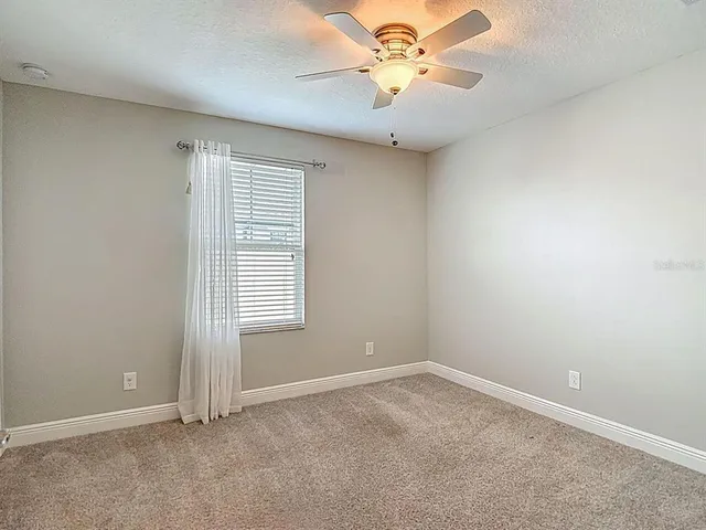 an empty room with closet and a chandelier fan