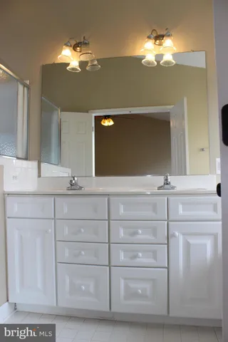 a bathroom with a sink vanity and a mirror