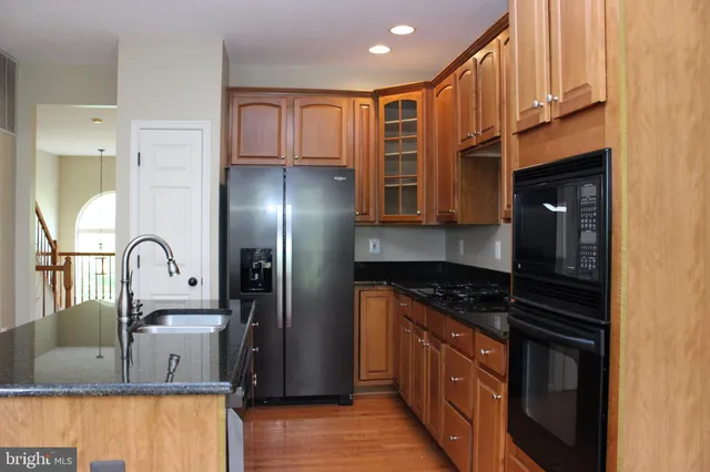 a kitchen with stainless steel appliances granite countertop a stove a sink and a refrigerator