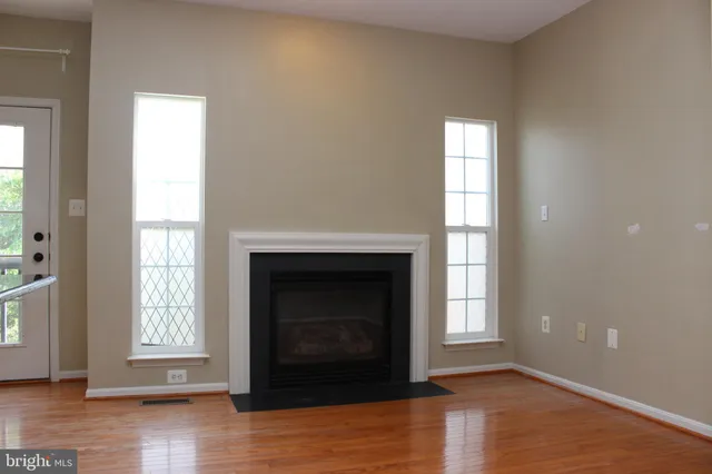 a living room with a fireplace and wooden floor
