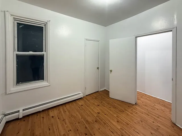 a view of a hallway with wooden floor and closet