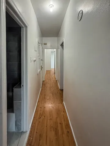 a view of a hallway with wooden floor and staircase