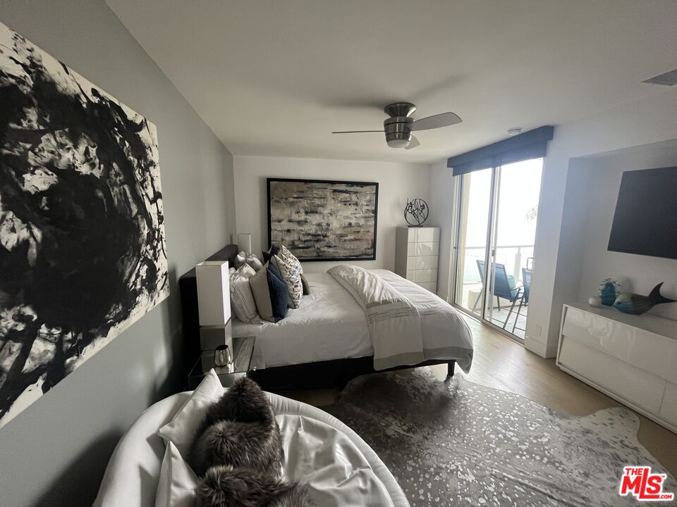 723 Palisades Beach Road, Unit 211 Santa Monica, CA 90402 - Photo 12 of 30 a bed sitting in a bedroom next to a window with pc on the wall