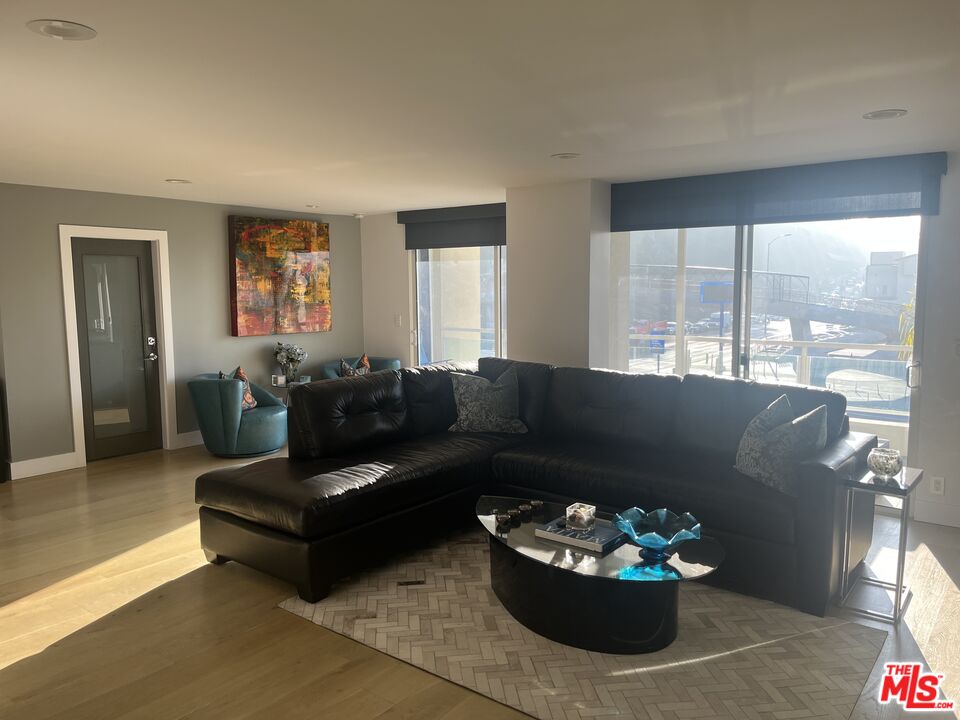 723 Palisades Beach Road, Unit 211 Santa Monica, CA 90402 - Photo 4 of 30 a living room with furniture potted plant and a window