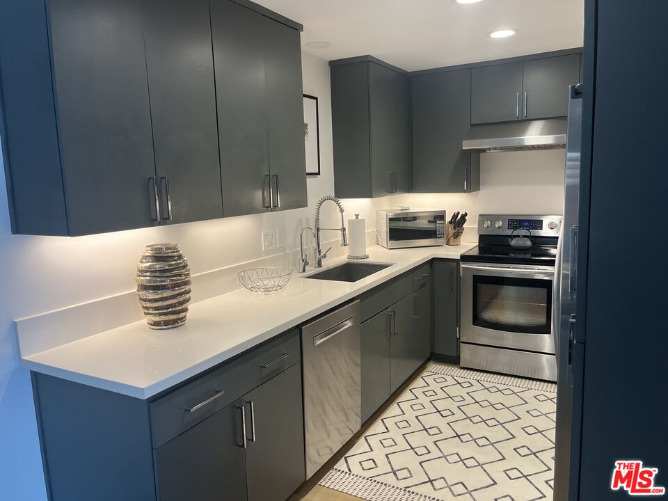 723 Palisades Beach Road, Unit 211 Santa Monica, CA 90402 - Photo 5 of 30 a kitchen with stainless steel appliances kitchen island granite countertop a sink stove and refrigerator