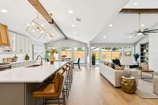 a living room with furniture kitchen view and a large window